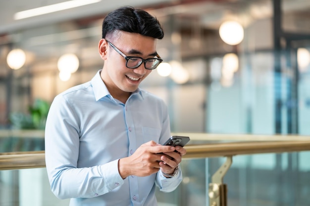 Retrato masculino de empresário asiático em seu local de trabalho