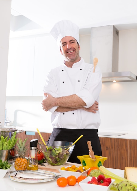 Retrato masculino do chef na bancada branca na cozinha