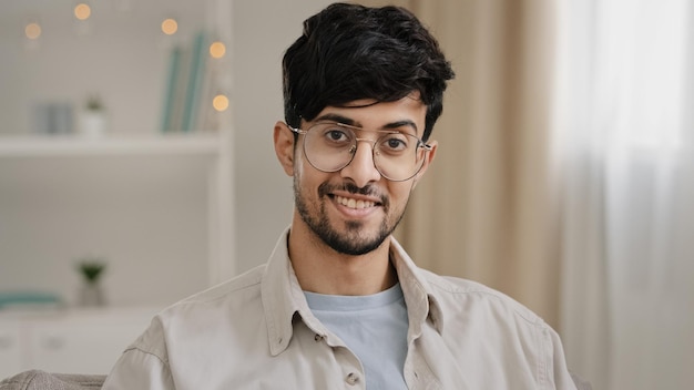 Retrato masculino primer plano rostro barbudo hombre indio árabe milenario con gafas mirando a la cámara