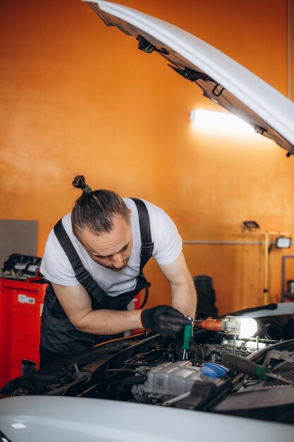 Retrato de un mecánico que revisa las piezas de un automóvil