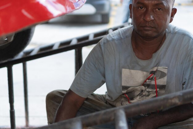 Retrato de un mecánico que trabaja debajo del vehículo en un taller.