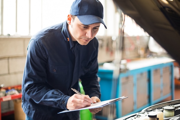 Foto retrato de un mecánico en el trabajo en su garaje