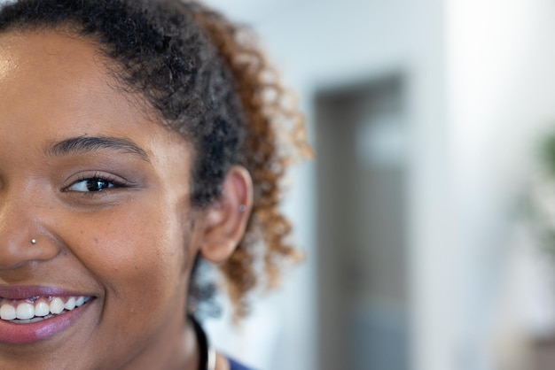 Retrato de media cara de una doctora afroamericana sonriente en el pasillo del hospital, con espacio para copiar. Servicios hospitalarios, médicos y sanitarios.