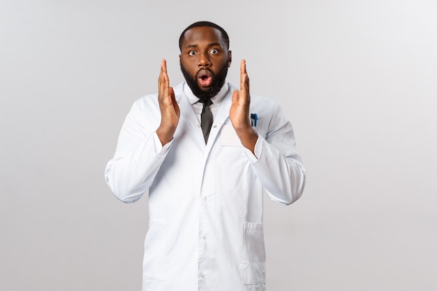 Retrato médico afroamericano en uniforme blanco.