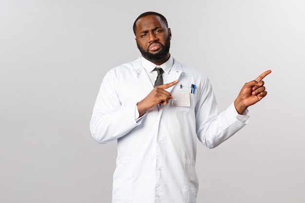 Retrato médico afroamericano en uniforme blanco.