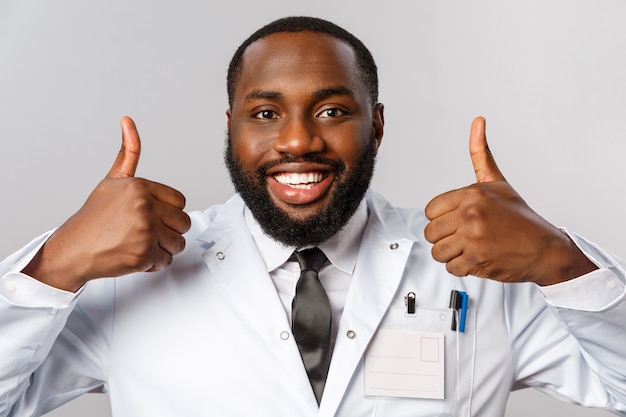 Retrato médico afroamericano en uniforme blanco.