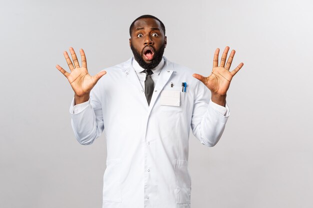 Retrato médico afroamericano en uniforme blanco.