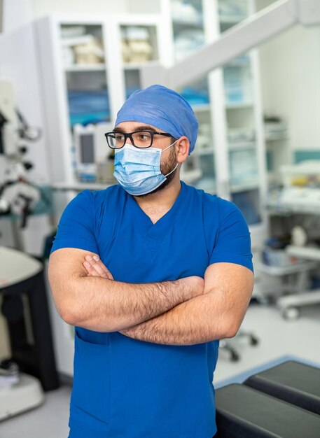 Retrato de un médico de alto rango con los brazos cruzados en el consultorio médico y mirando a la cámara Cara pensativa de un médico experimentado