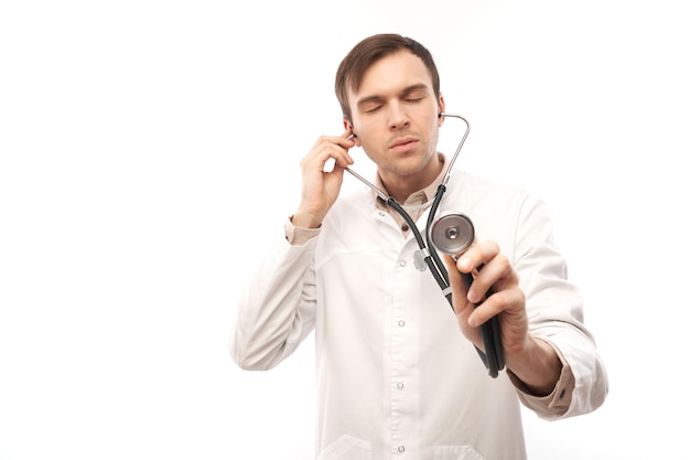 Retrato de un médico apuesto con bata médica blanca con estetoscopio sobre fondo blanco con espacio para copiar