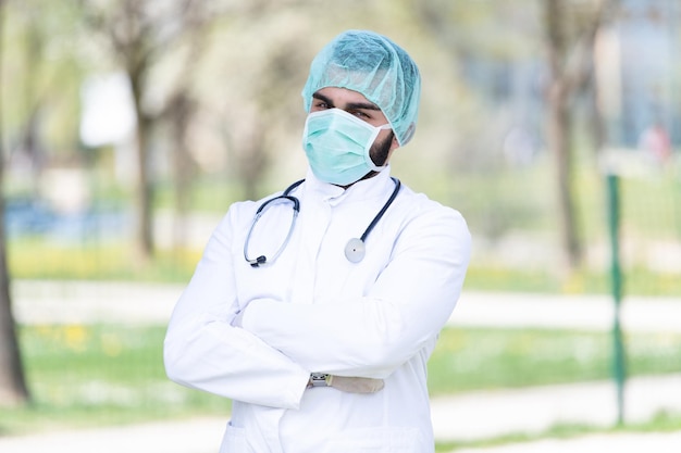 Retrato de un médico caucásico cansado y exhausto frente a un parque - Enfermedad del virus Coronavirus Covid-19 - Brote pandémico global