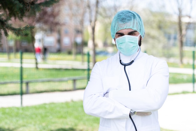 Retrato de un médico caucásico cansado y exhausto frente a un parque - Enfermedad del virus Coronavirus Covid-19 - Brote pandémico global