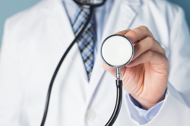 Foto retrato de un médico con estetoscopio para el examen físico