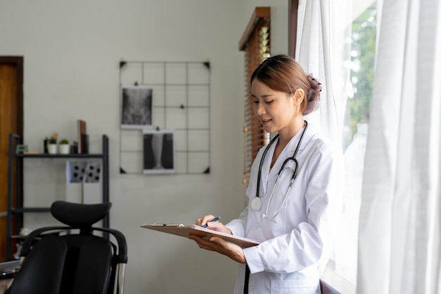 Retrato médico femenino asiático tomando nota en el portapapeles en su oficina