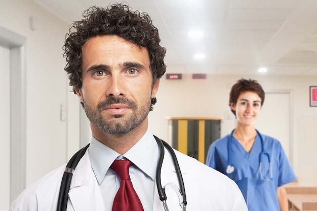 Retrato de un médico guapo. Enfermera en el fondo