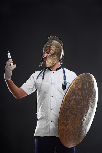 Retrato de un médico guerrero medieval en un casco sosteniendo una jeringa