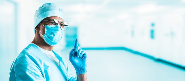 Retrato de un médico en un hospital. Con optimismo, levanta el dedo. El concepto de nuevas ideas en medicina.