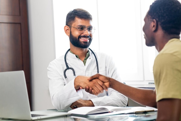 Retrato de un médico indio hablando con un paciente en consulta