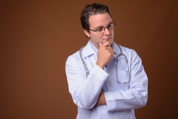 Foto retrato de médico italiano contra la pared marrón