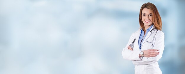 Retrato de un médico joven y bella mujer sobre un fondo azul.