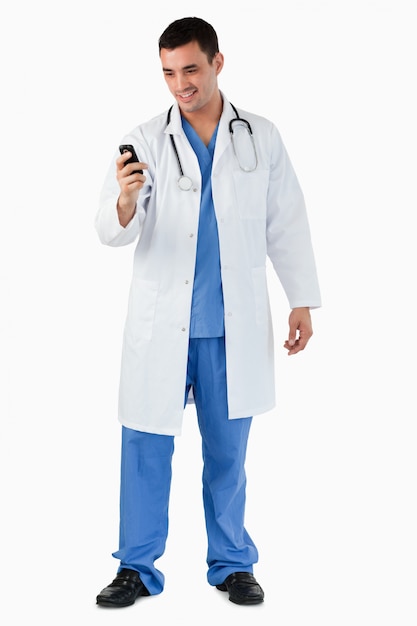 Retrato de un médico marcando en su teléfono móvil