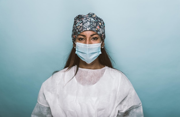 Retrato de un médico con una máscara de pie contra la pared