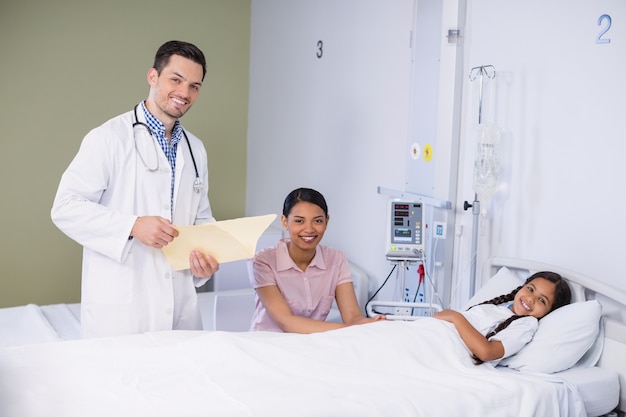 Retrato de médico y niña paciente en cama de hospital