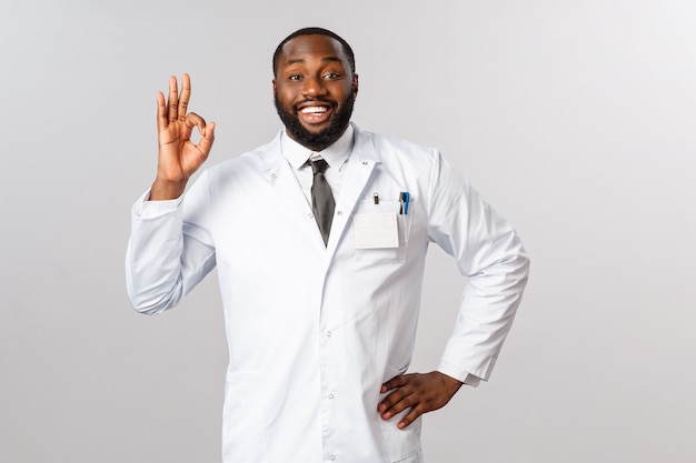 Retrato de médico o médico afroamericano en uniforme blanco.