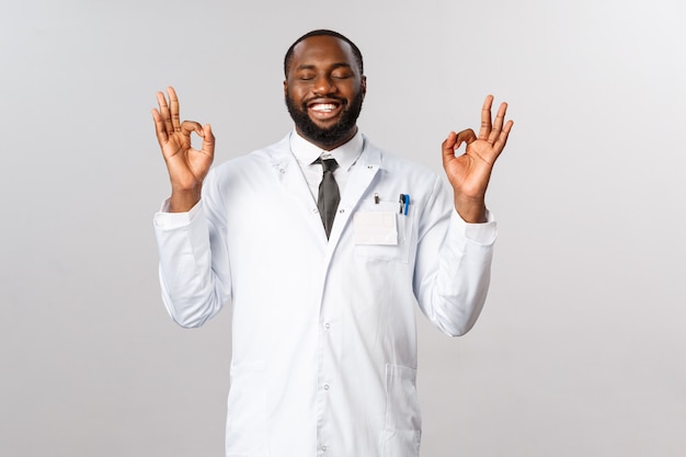 Retrato de médico o médico afroamericano en uniforme blanco.