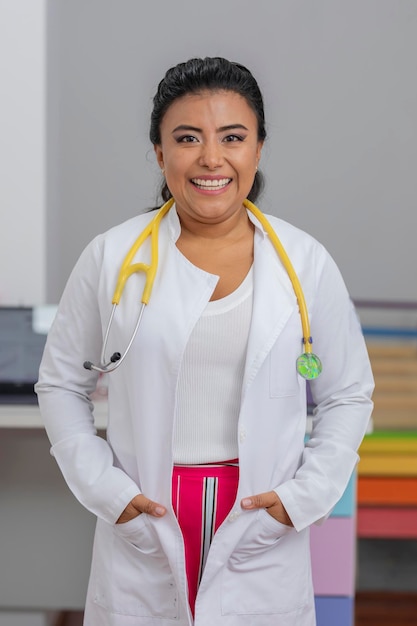 Retrato de un médico pediatra sonriente en su oficina con una bata de laboratorio y un estetoscopio