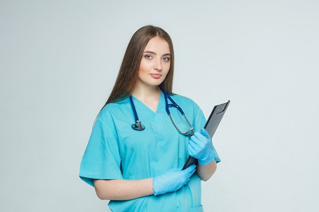 Retrato de un médico con portapapeles y estetoscopio aislado en una pared blanca