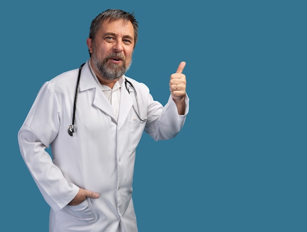 Retrato de un médico sonriente con estetoscopio posando sobre fondo blanco.