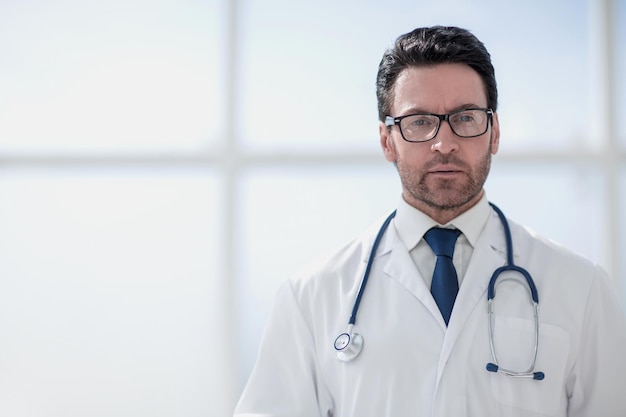 Retrato de un médico sonriente en una habitación luminosa de la clínica.Foto con espacio de texto