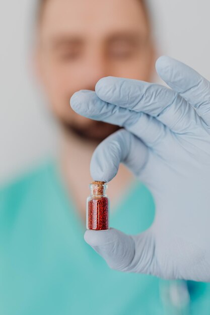 Retrato de un médico sonriente sosteniendo una botella con tabletas o píldoras para tratamiento aislado en whi