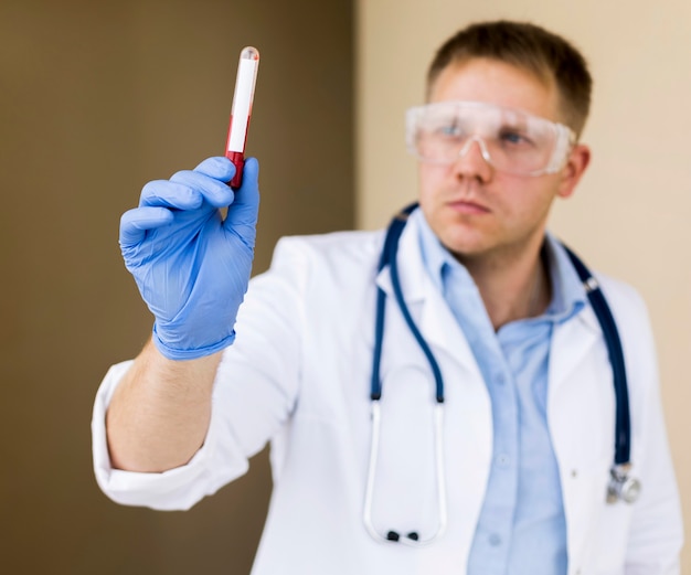 Foto retrato de un médico sosteniendo una muestra de covid