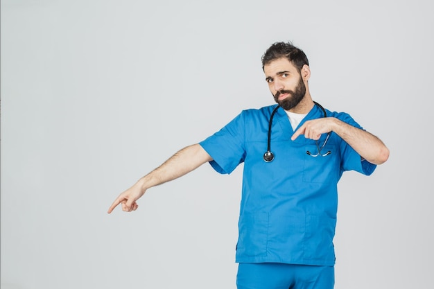 Retrato de médico en uniforme azul con sus pulgares hacia arriba Aislado sobre fondo blanco medicina y salud de la gente