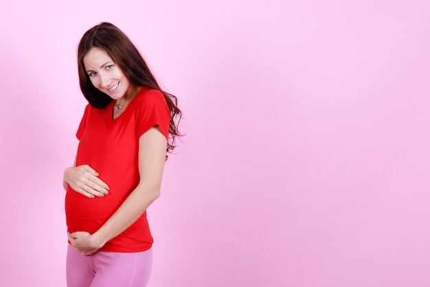 Retrato de medio cuerpo de la hermosa modelo caucásica joven embarazada acariciando tierno tocar su vientre Embarazada feliz nueva madre posando interior poner la mano tocando suavemente la barriga Concepto de amor y familia