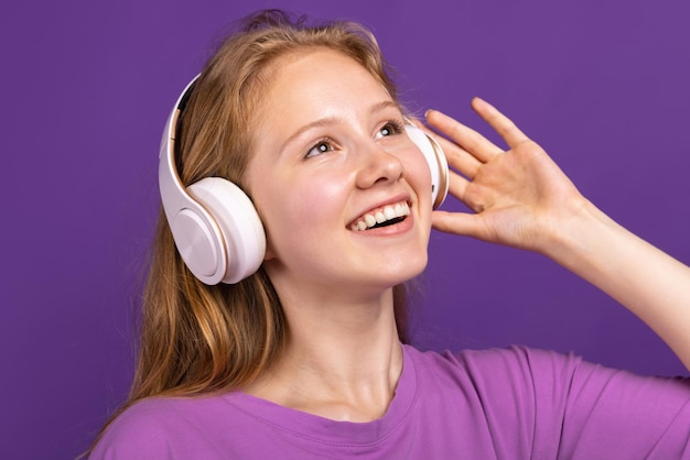 Retrato de medio cuerpo de una joven hermosa niña sonriente aislada en el concepto de fondo de estudio púrpura de