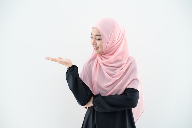 Retrato de medio cuerpo de mujer asiática musulmana hermosa asiática con atuendo de negocios y el hijab con poses mixtas y gestos aislados en la pared gris. Adecuado para la tecnología, el tema de las finanzas empresariales.