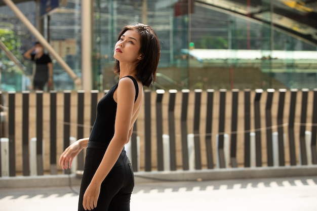 Retrato de medio cuerpo de mujer con cabello negro recto y camisa de vestir formal. mujer se siente feliz de caminar