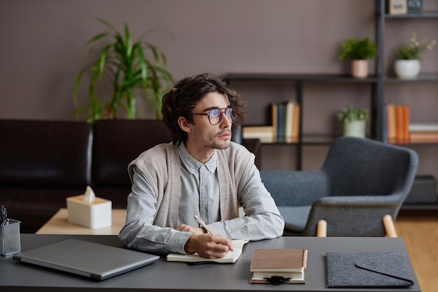 Retrato médio horizontal de um jovem adulto bonito vestindo roupa casual elegante com óculos