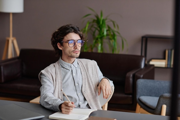 Retrato médio horizontal de um jovem psicoterapeuta adulto bonito vestindo uma roupa casual estilosa