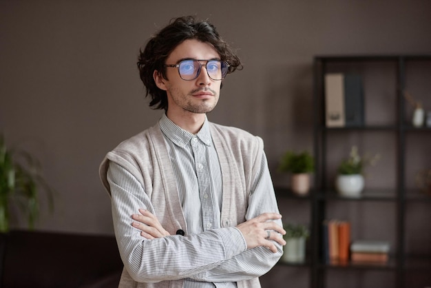 Retrato medio horizontal de un hombre caucásico joven y apuesto que viste un elegante atuendo informal de pie en