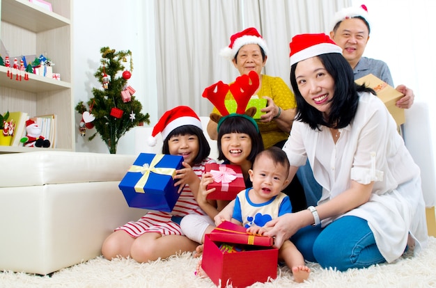 Retrato de miembros de la familia felices en tapas de Santa en la víspera de Navidad