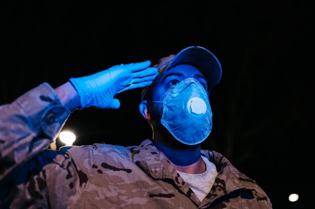 Foto retrato de un militar saludando con máscara