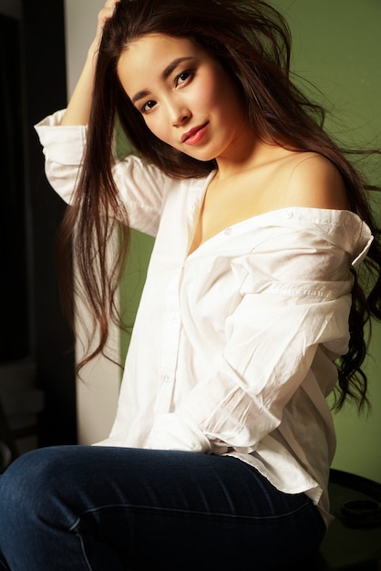 Retrato de la moda de la belleza de la mujer joven asiática sensual atractiva sonriente con el pelo largo oscuro en la camisa blanca