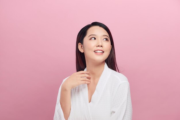 Retrato de moda de belleza. Mujer joven sonriente sobre fondo de pared rosa.