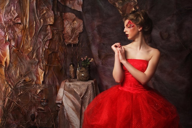 Retrato de moda de una chica hermosa y romántica con un vestido de arte de labios rojos peinado Princesa en casa misteriosa Concepto creativo Érase una vez en la fantasía