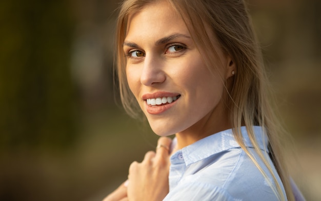 Retrato de moda de estilo de vida al aire libre de feliz impresionante chica rubia.