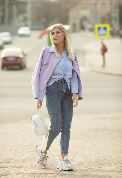 Retrato de moda de estilo de vida al aire libre de feliz impresionante chica rubia.