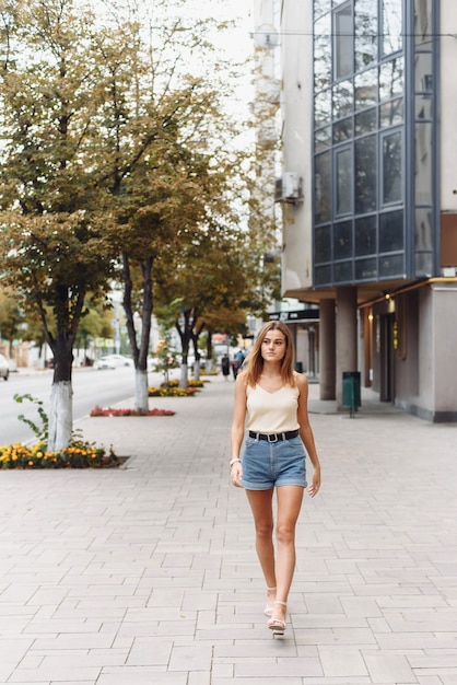 Retrato de moda de estilo de vida soleado de verano de mujer joven inconformista con estilo caminando
